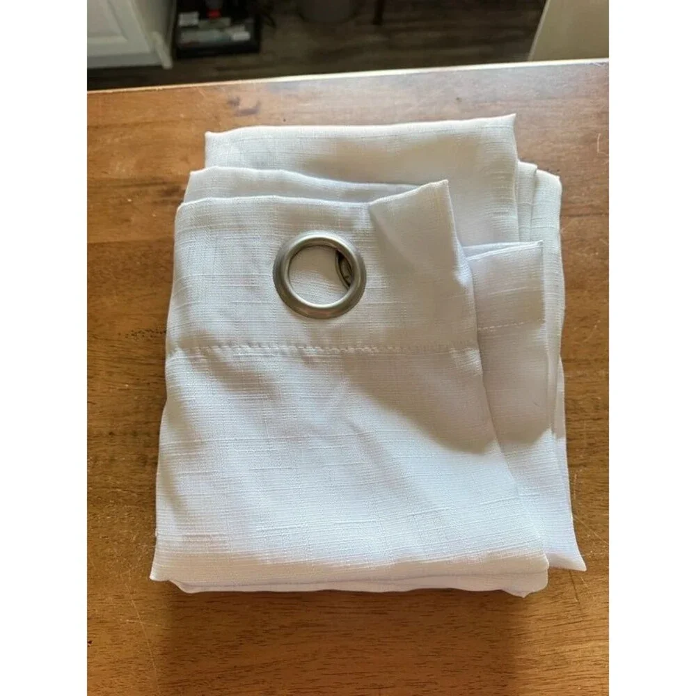 Two panels of white curtains with grommets